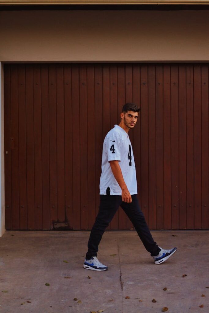 Stylish man posing casually against a garage backdrop in Sete Lagoas.